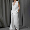 	Woman wearing white cotton linen sleeveless top and pants set with red shoes