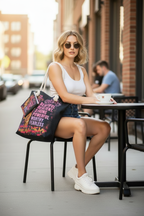 Young woman at outdoor cafe with She is Beautiful Resilient Strong canvas tote bag and matching wallet – lifestyle photo