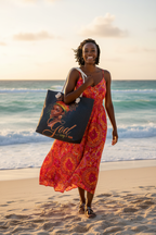 Confident Black woman carrying God Say I Am canvas tote bag on a sunny beach – empowering lifestyle photo